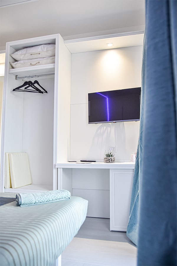 Crabonaxa Suites - Villasimius - Schlafzimmer mit TV und Kleiderschrank